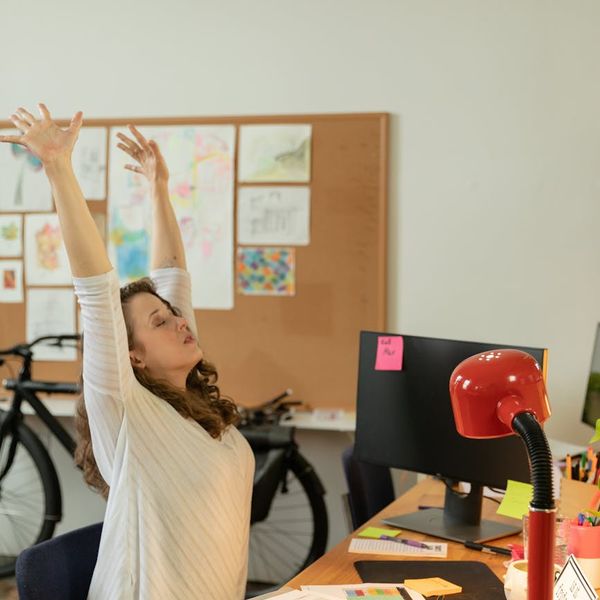 Office worker stretching at their desk during a break.